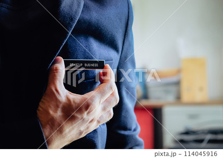 businessman holding a startup business label in his hand 114045916