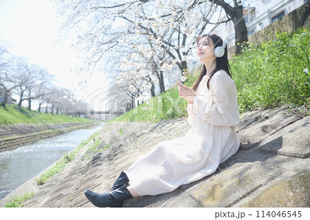 桜の下で音楽を聴く女性 114046545