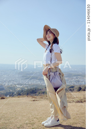 丘の上で遠くを見つめる女性 114046630