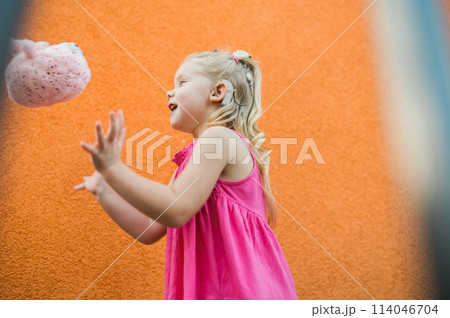 Funny baby with cochlear implant walks outdoor. Hearing aid and medicine innovating technology concept. Diversity and Inclusion and people with disability concept. 114046704