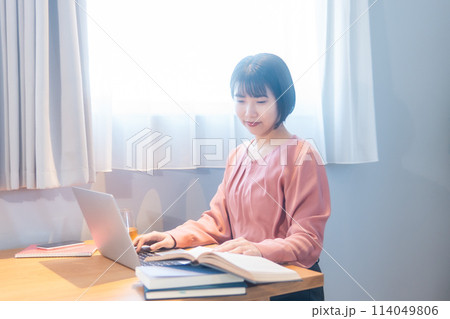 自宅で勉強/リモートワークをする女性 114049806