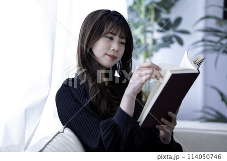 休日にソファで読書する若い女性 休日にソファで読書する若い女性 114050746