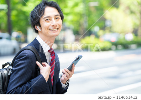 ワイヤレスイヤホンをしているビジネスマン 114051412