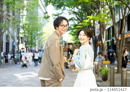 笑顔で街を歩く若いカップル 114051427