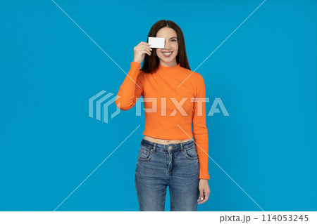 Happy young girl with a card in her hand on a blue background. Happy young girl with a card in her hand on a blue background. 114053245
