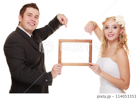 wedding couple pointing empty frame for photo. wedding couple pointing empty frame for photo. 114053351