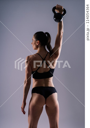 Sport, active lifestyle concept. Smiling strong and slim fitness female athlete holding kettlebell Sport, active lifestyle concept. Smiling strong and slim fitness female athlete holding kettlebell 114054364