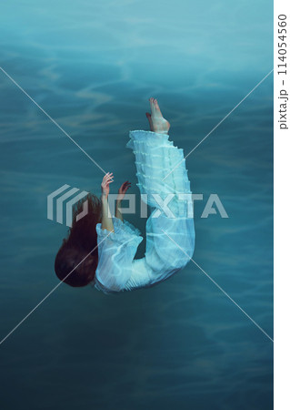 Elegant young woman in light dress in a peaceful, underwater pose, diving and levitating underwater. Fantasy book cover template Elegant young woman in light dress in a peaceful, underwater pose, diving and levitating underwater. Fantasy book cover template 114054560