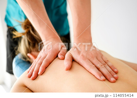 Massage therapist doing back massage in spa Salon. Healthcare and relaxation procedures. 114055414