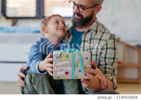 Dad get a handmade gift from little son, present wrapped in diy homemade wrapping paper. Happy Fathers day concept. 114055669
