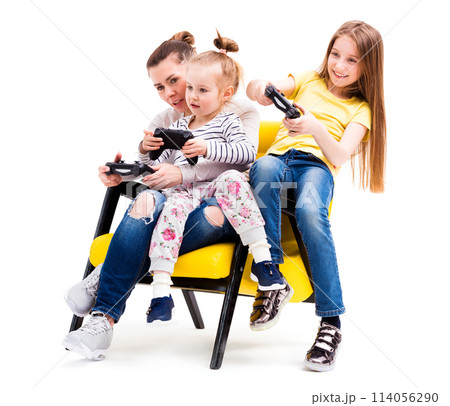 Mom and daughters spending time on computer games on playing console, using joystick Mom and daughters spending time on computer games on playing console, using joystick 114056290