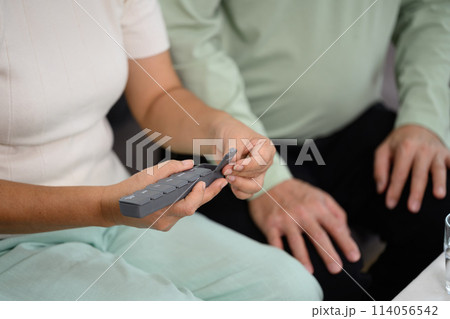 Senior woman sorting pills into pills organizer. Health care, medicine and treatment concept 114056542