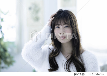 白ニットを着たフェミニンな雰囲気の若い女性 白ニットを着たフェミニンな雰囲気の若い女性 114056767