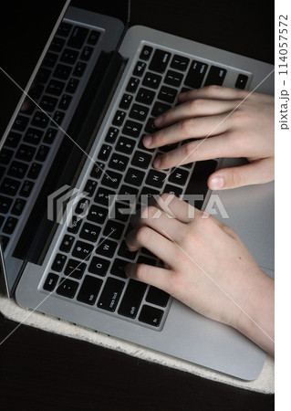 Detailed image of a young person's palms poised above a laptop keyboard, symbolizing proficiency in digital communication and computer usage. 114057572