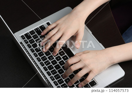 Teenager's hands in close-up position on a laptop keyboard, illustrating a fluency in technology and digital literacy. 114057573