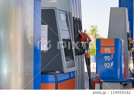Petrol station with colored guns and fuel hoses. Gasoline, diesel, eco hydrogen refueling column.. Close-up Petrol station with colored guns and fuel hoses. Gasoline, diesel, eco hydrogen refueling column.. Close-up 114059182