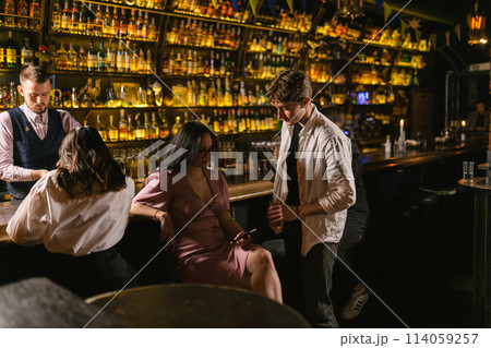 Pretty female ignores man with cocktail at work event in pub Pretty female ignores man with cocktail at work event in pub 114059257