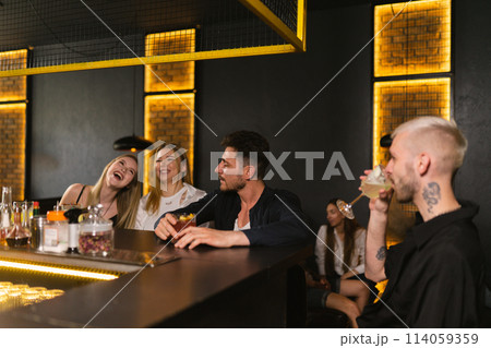 Men sit near laughing drunk ladies look back at laughter 114059359