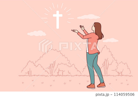 Catholic woman looks at cross glowing in sky, praying to god for help in finding right path 114059506