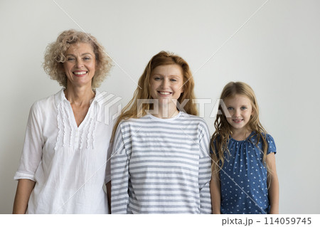 Three smiling beautiful relatives women posing on gray studio background Three smiling beautiful relatives women posing on gray studio background 114059745