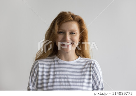 Happy millennial red-headed woman laughing look at camera Happy millennial red-headed woman laughing look at camera 114059773