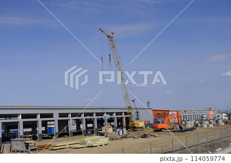 Silhouettes of tower crane against a blue sky withe clouds. House under construction. Industrial skyline Silhouettes of tower crane against a blue sky withe clouds. House under construction. Industrial skyline 114059774