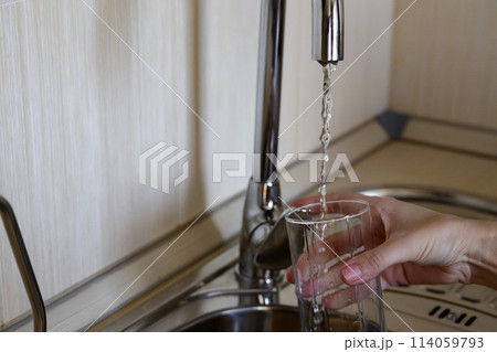 A woman in rubber gloves cleans the sink with detergent. House cleaning. A woman in rubber gloves cleans the sink with detergent. House cleaning. 114059793