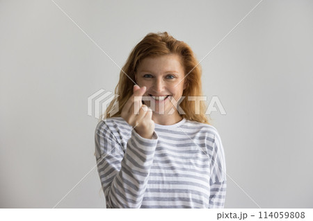 Studio portrait of attractive ginger woman showing cash gesture Studio portrait of attractive ginger woman showing cash gesture 114059808