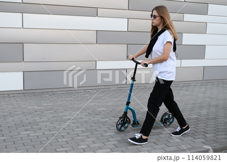 Beautiful and blonde girl practicing long board on the road Beautiful and blonde girl practicing long board on the road 114059821