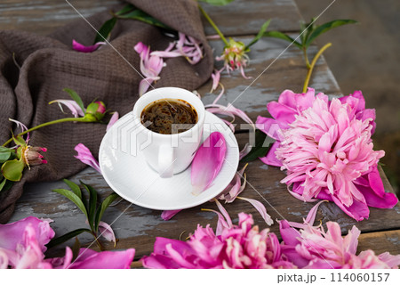 Pink peony flowers and a cup of coffee on a white background. Morninig, spring, fashion composition. Flat lay, top view, copy space. Pink peony flowers and a cup of coffee on a white background. Morninig, spring, fashion composition. Flat lay, top view, copy space. 114060157