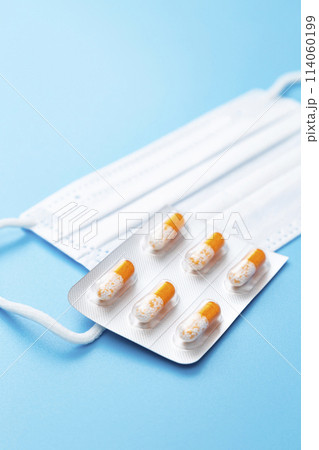 青背景にカプセル錠とマスク 114060199