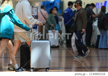 スーツケースを引く旅行客 羽田空港 出発ロビー 旅行客 スーツケースを引く旅行客 羽田空港 出発ロビー 旅行客 114060320