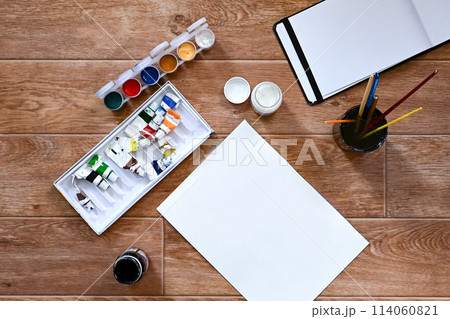 A set of gouache and paints for drawing on a white sheet. The concept of creativity and hobbies. 114060821
