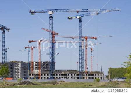 Construction of new residential high-rise buildings. Against the background of a yellow sunset sky. Construction of new residential high-rise buildings. Against the background of a yellow sunset sky. 114060842