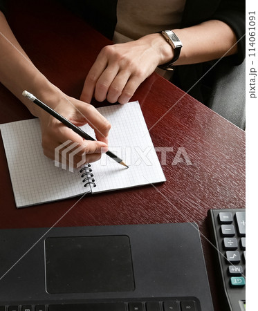 Rear view of female financial manager drawing various charts and schemes on wall in office Rear view of female financial manager drawing various charts and schemes on wall in office 114061091