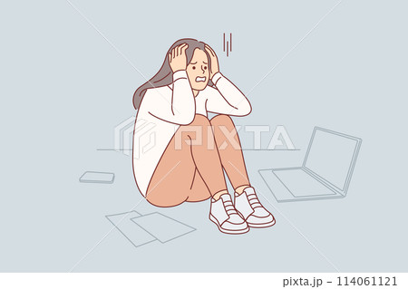 Upset cold woman suffering from stress or burnout, sitting on floor near papers and laptop Upset cold woman suffering from stress or burnout, sitting on floor near papers and laptop 114061121