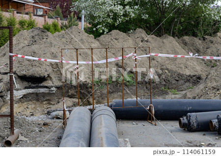 Laying of underground storm sewer pipes at a construction site. Installation of water supply and sanitary sewerage. Pipes of the groundwater drainage system Laying of underground storm sewer pipes at a construction site. Installation of water supply and sanitary sewerage. Pipes of the groundwater drainage system 114061159
