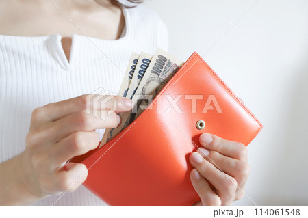 財布からお金を出す女性 114061548