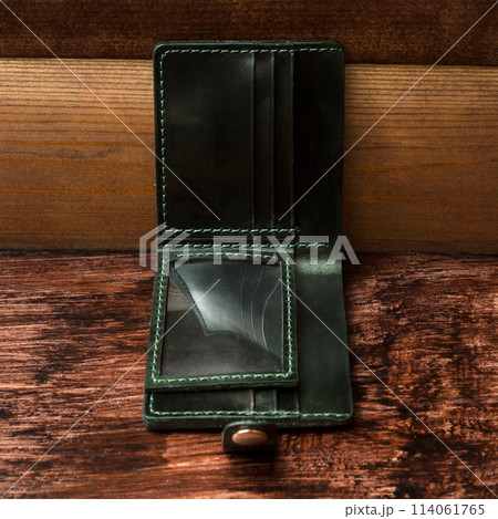 Men's wallet made of black leather on dark stylish wood. Shooting for the catalog Men's wallet made of black leather on dark stylish wood. Shooting for the catalog 114061765