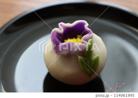 黒塗りの丸い菓子皿に紫のグラデーションが美しい上生菓子 114061995