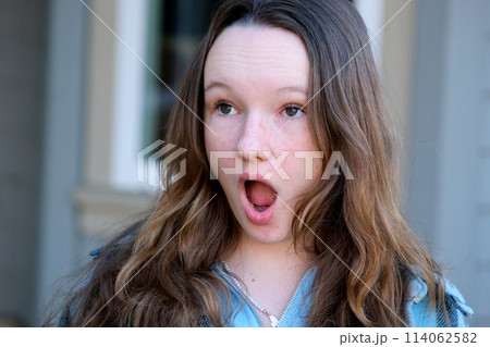 Beautiful european cute teen girl get surprised when look at copy space. Surprised happy beautiful woman looking copy space in exciting. use for your product, advertising.  114062582