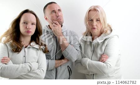 three dissatisfied indignant people a man two women a young teenage girl middle-aged people look evilly into the frame and dance an angry look 114062782