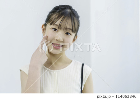 舌を出して指を頬に当ててポーズを取る小学生の女の子のポートレート 舌を出して指を頬に当ててポーズを取る小学生の女の子のポートレート 114062846