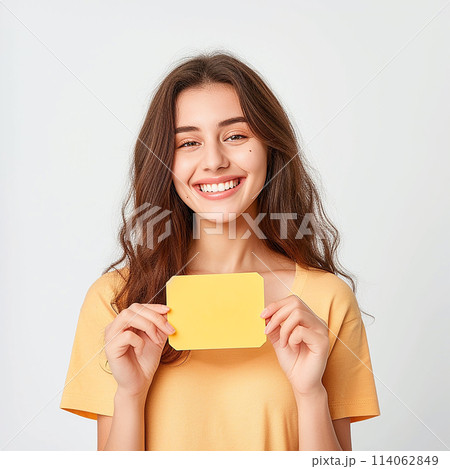 smiling woman holding a sign, a piece of paper in her hands smiling woman holding a sign, a piece of paper in her hands 114062849