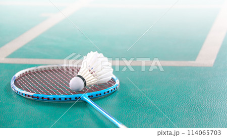 White badminton shuttlecocks and badminton rackets on green floor indoor badminton court White badminton shuttlecocks and badminton rackets on green floor indoor badminton court 114065703