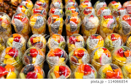 Fruit Salad arranged in plastic cups on a market. Cut and ready fruit ready to sell in market. Convenience, healthy lifestyle. Strawberries, kiwi, melon, pineapple, figs, dragon in a plastic glass. Fruit Salad arranged in plastic cups on a market. Cut and ready fruit ready to sell in market. Convenience, healthy lifestyle. Strawberries, kiwi, melon, pineapple, figs, dragon in a plastic glass. 114066854
