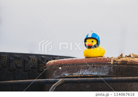 Small yellow rubber duck in motorcycle helmet. Travel symbol, car toy. 114067618