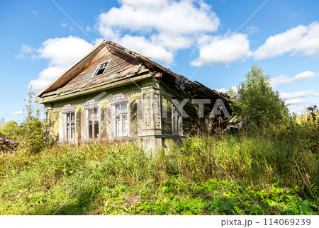 Abandoned destroyed rural wooden house in russian village in summer sunny day 114069239
