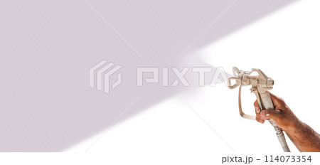 Professional Spray Painter Holding Spray Gun Spraying Purple Over White Surface. Professional Spray Painter Holding Spray Gun Spraying Purple Over White Surface. 114073354