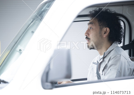 トラックを運転する中年の作業着のガテン系の男性 運送や配送業などで交通事故にあった時に驚くイメージ トラックを運転する中年の作業着のガテン系の男性 運送や配送業などで交通事故にあった時に驚くイメージ 114073713